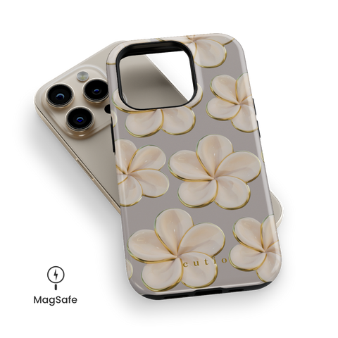 Beach Date - Ivory MagSafe phone case featuring glossy ivory plumeria flowers with golden edges on a warm grey background, top down view on iPhone