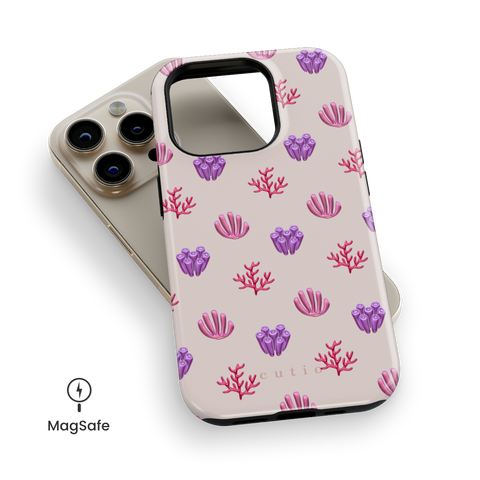 Blooming Coral MagSafe phone case featuring glossy red, pink, and purple coral motifs scattered over a pale blush background, top down view on iPhone
