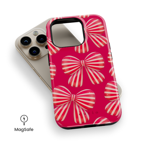 Bow Chic MagSafe phone case featuring bold, eye-catching red-striped bows on a vibrant red backdrop, top down view on iPhone
