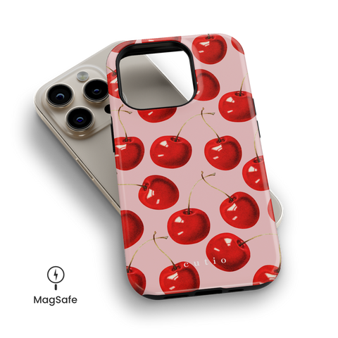 Cherry On Top MagSafe phone case featuring luscious red cherries on salmon pink background, top down view on iPhone