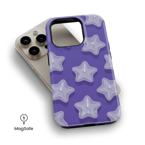 Dreamer MagSafe phone case featuring star-shaped pearls on blueish purple background design, top down view on iPhone