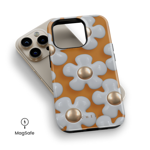 Flower Charm MagSafe phone case featuring elegant 3D metallic white daisies on a warm mustard yellow background, top down view on iPhone
