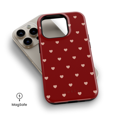 Full Of Hearts MagSafe phone case featuring cute and playful pink hearts pattern on bold red background, top down view on iPhone