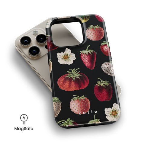 Merry Berry MagSafe phone case featuring red, pink and white strawberries on black background design, top down view on iPhone