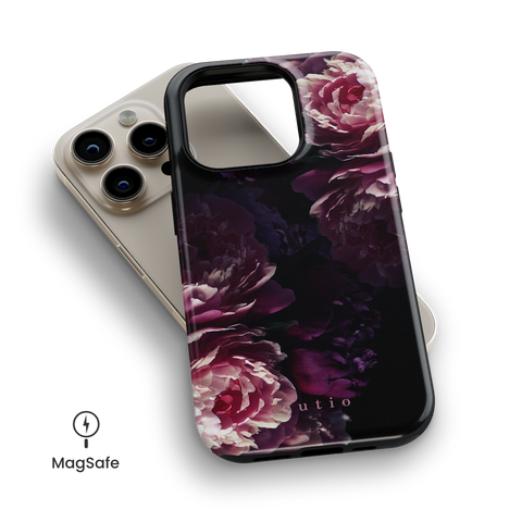 Midnight Blooms MagSafe phone case featuring pink and purple peonies on black background design, top down view on iPhone