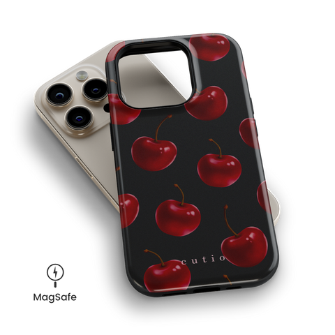 Temptation MagSafe phone case featuring luscious red cherries on black background, top down view on iPhone