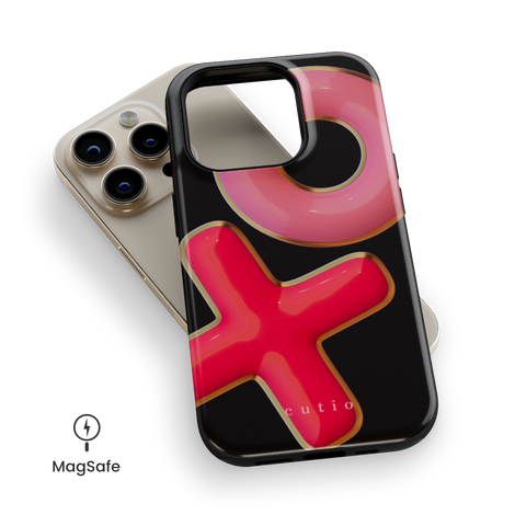 XO MagSafe phone case featuring 3D-effect XO design in bright red and pink with gold trim accents on a black background, top down view on iPhone