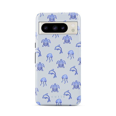 Blue Drift tough phone case featuring glossy blue turtles, dolphins, and jellyfish floating on a cool pale blue background, front view on Google Pixel phone
