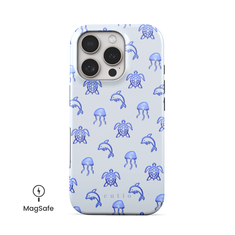 Blue Drift MagSafe phone case featuring glossy blue turtles, dolphins, and jellyfish floating on a cool pale blue background, front view on iPhone