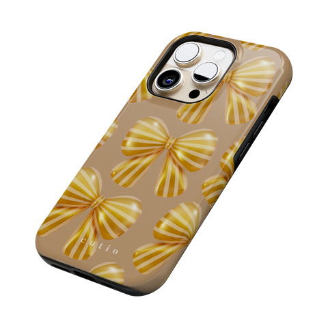Bow Chic - Gold tough phone case featuring bold, eye-catching gold-striped bows on a muted gold backdrop, side view on iPhone