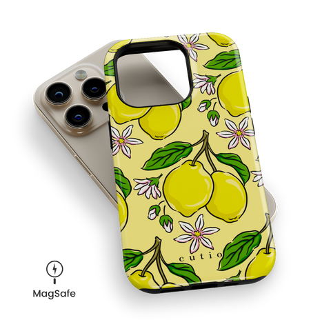 Lemony MagSafe phone case featuring bright yellow lemons with green leaves and white-pink citrus flowers on a soft lemon background, top down view on iPhone