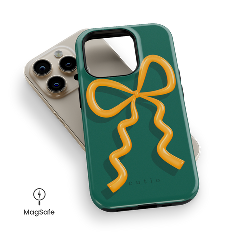 Present Moment - Green MagSafe phone case featuring a glossy orange bow design on a rich green background, resembling a gift wrap ribbon, top down view on iPhone
