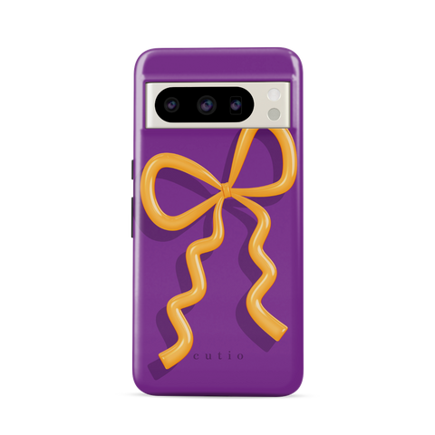 Present Moment - Purple tough phone case featuring a glossy orange bow design on a rich purple background, resembling a gift wrap ribbon, front view on Google Pixel phone