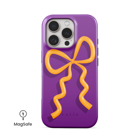Present Moment - Purple MagSafe phone case featuring a glossy orange bow design on a rich purple background, resembling a gift wrap ribbon, front view on iPhone