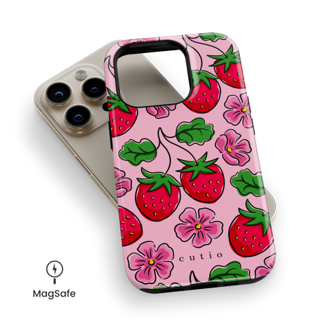 Strawberry Patch MagSafe phone case featuring hand-drawn red strawberries with green leaves and pink flowers on a soft pink background, top down view on iPhone