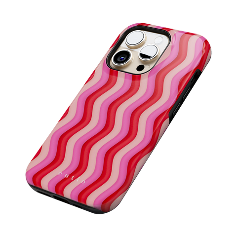 Unwind tough phone case featuring bold Y2K-inspired groovy waves design in red, pink, and beige tones, side view on iPhone