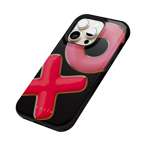 XO tough phone case featuring 3D-effect XO design in bright red and pink with gold trim accents on a black background, side view on iPhone